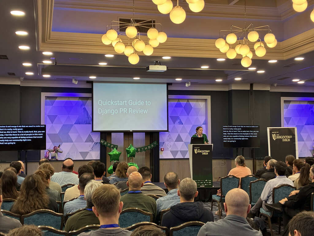 Django Fellow Sarah Boyce on stage at DjangoCon Europe 2025, with audience in the foreground