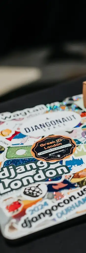 Laptop with stickers for DjangoCon US 2024, DjangoCon Europe 2024, Django London, Djangonaut Space, Django Girls