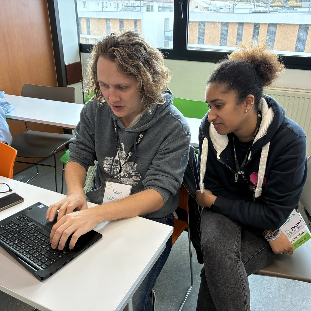 Two contributors working together on a laptop pair programming