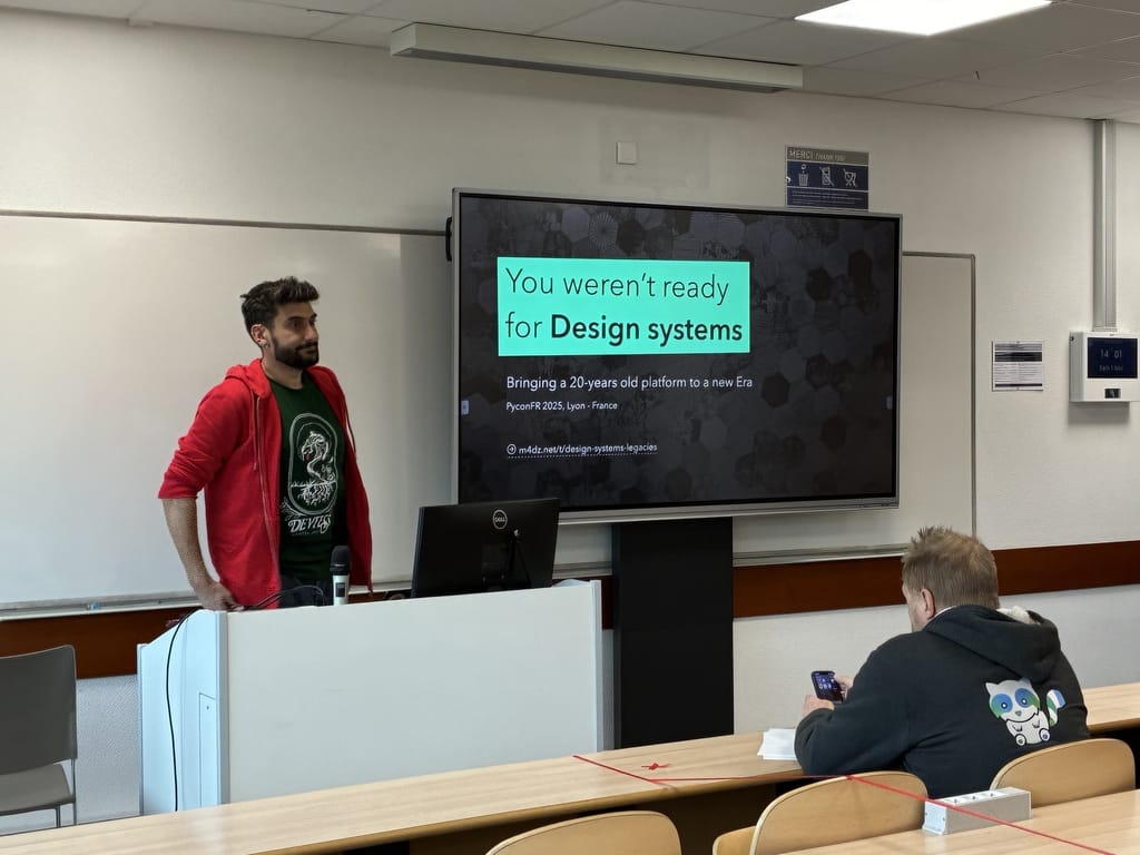 Mads on stage with title slide about design systems at PyCon FR