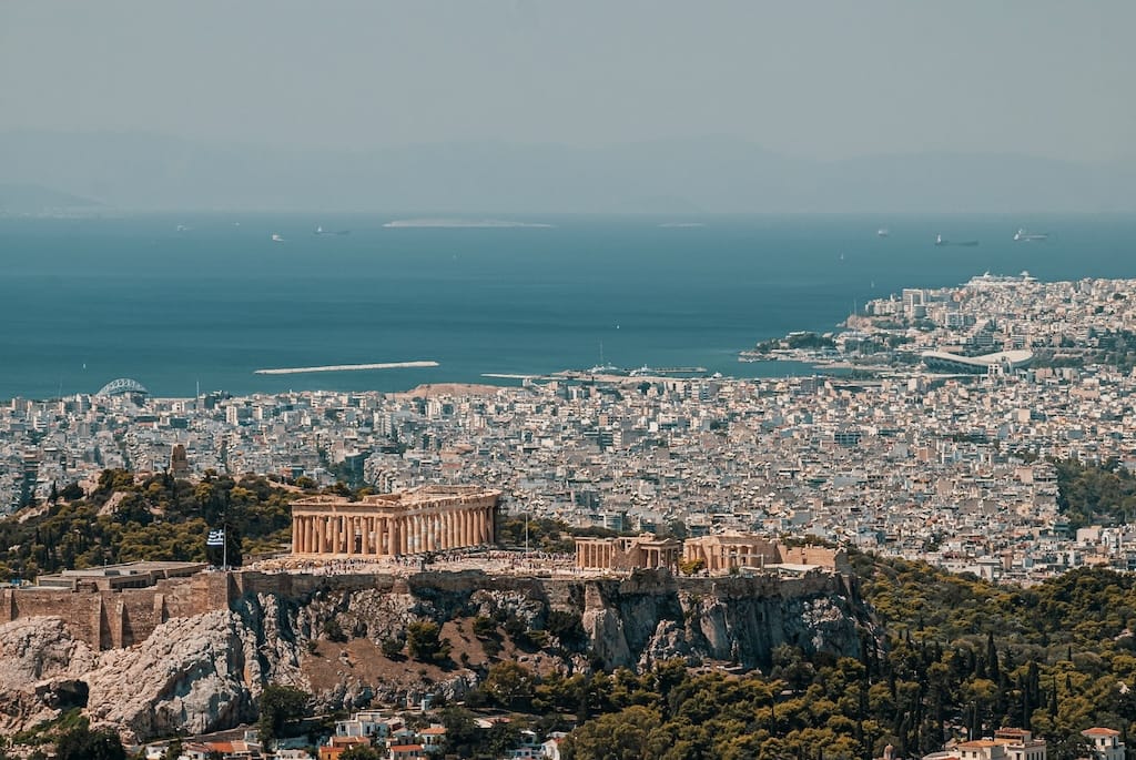 Panorama of Athens with the city skyline. The Mediterranean sea in the background, and the Acropolis in the foreground